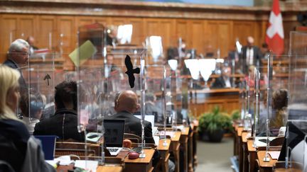 Des vitres en plexiglas ont été installées autour de chaque élu du Parlement suisse. (FABRICE COFFRINI / AFP)