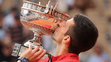 Novak Djokovic embrasse son trophée après avoir gagné la finale de Roland-Garros, dimanche 11 juin 2023. (MAYA VIDON-WHITE / MAXPPP)