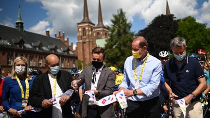 L'ancien ministre des Affaires étrangères, Jean-Yves Le Drian (à gauche), lors du départ de la deuxième étape du Tour de France, au Danemark, avec le ministre danois des Transports (au milieu) et le directeur général de la course, Christian Prudhomme (à droite). (MARCO BERTORELLO / AFP)