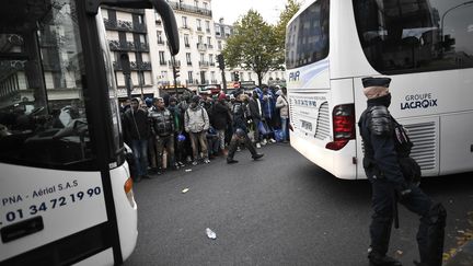 Des migrants patientent avant d'être évacués en bus vers des hébergements temporaires, le 4 novembre 2016, dans le 19e arrondissement de Paris. (AFP)