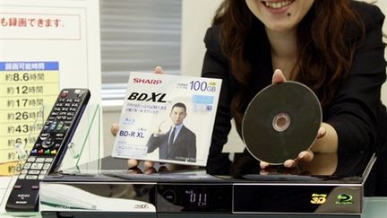 Une employée de Sharp présente le nouveau disque Blu-ray triple couche, à Tokyo, le 16 juillet 2010. (AFP PHOTO / Yoshikazu TSUNO)