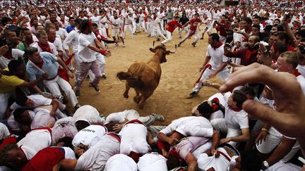 Une vachette fonce dans la foule lors des fiestas de San Fermin &agrave; Pampelune (Espagne), le 8 juillet 2012. (IVAN AGUINAGA / AP / SIPA)