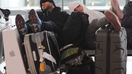 Des passagers dorment dans l'a&eacute;roport de Londres Heathrow (Royaume-Uni) apr&egrave;s que leur vol a &eacute;t&eacute; annul&eacute; en raison des intemp&eacute;ries, le 19 janvier 2013. (MAXPPP)