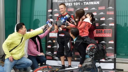 Le Polonais Krystian Herba r&eacute;pond aux sollicitations des m&eacute;dias apr&egrave;s son ascension &agrave; VTT de la tour Taipei 101 (Ta&iuml;wan), dimanche 22 mars 2015. (BENJAMIN YEH / AFP)