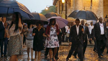 C'est en famille et sous une pluie battante que le président américain arpente les rues détrempées du centre de la capitale cubaine. Les intempéries et un important déploiement de forces de police ont contribué à vider cette partie de la ville, classée au Patrimoine mondial de l'Unesco. La famille Obama s'est notament rendue dans la cathédrale de La Havane où elle s'est entretenue avec le cardinal Jaime Ortega, l'un des artisans du rapprochement américano-cubain. Lors de sa visite historique de trois jours, Barack Obama doit rencontrer le président Raoul Castro ainsi qu'un groupe de dissidents.  (Reuters/Carlos Barria)