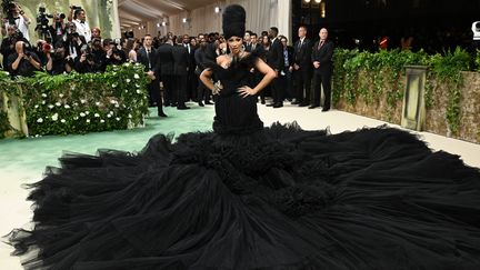 Le rappeur Cardi B a réinterprété le jardin sous une forme gothique.  Le noir s'audace avec Windowsen, une des marques chinoises émergentes.  On retrouve les inspirations dramatiques de la créatrice avec cette robe géante aux multiples épaisseurs de tulle, façon rose délavé.  De nombreuses personnes ont dû soulever ce gigantesque train pour aider le rappeur à se déplacer.  (GILBERT FLORES / VARIÉTÉ)