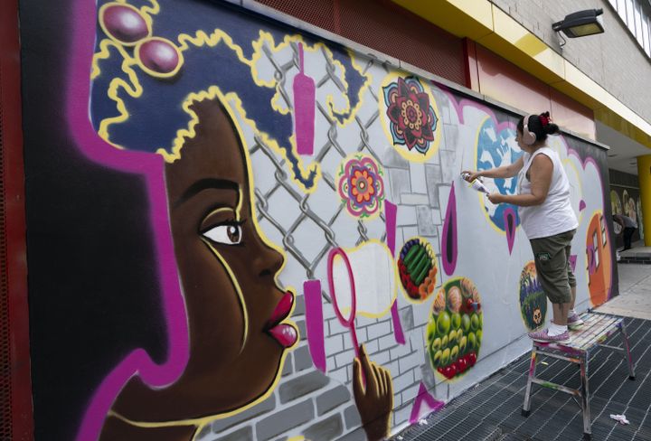 La graffeuse Lady Pink réalise une fresque dans le quartier du Bronx à New York le 2 juin 2019. (DON EMMERT / AFP)