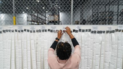 Dans un bureau de vote de Fairburn, en Géorgie, les assesseurs exposent les reçus des votes par correspondance lors du dépouillement, mardi 5 novembre. (MEGAN VARNER / GETTY IMAGES)