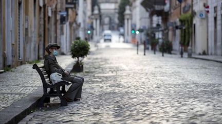 Une femme est assise sur un banc le 11 avril 2020 dans une rue déserte de Rome, en Italie, pays où le coronavirus a fait plus de 20 000 morts depuis le début de la crise. (MASSIMO PERCOSSI / ANSA)