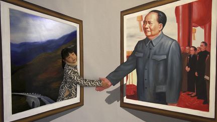 Une petite fille pose &agrave; c&ocirc;t&eacute; d'une peinture en 3D de l'ancien leader chinois Mao&nbsp;Ts&eacute;-toung lors d'une exposition &agrave; Binzhou (Chine), le 15 d&eacute;cembre 2013. (REUTERS)