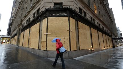 Rues d&eacute;sertes balay&eacute;es par la pluie, transports en commun et attractions touristiques ferm&eacute;es : New York est paralys&eacute;e. (TIMOTHY A. CLARY / AFP)