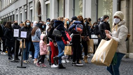 Des personnes masquées font la queue devant un magasin à Genève, en Suisse, le 16 janvier 2021. (FABRICE COFFRINI / AFP)