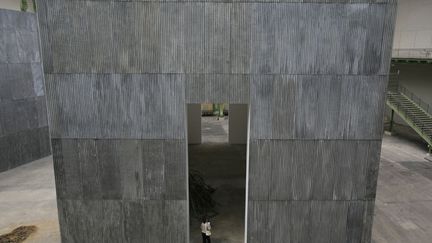 Tr&ocirc;nant au milieu d'immenses cubes de t&ocirc;le ondul&eacute;e, c'est une tour effondr&eacute;e intitul&eacute;e "Verungl&uuml;kte Hoffnung" (Espoir accident&eacute;), qui accueille le visiteur. (VINCENT NGUYEN / AFP)