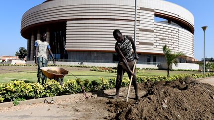 Des jardiniers travaillent devant le musée des Civilisations noires (MCN) à Dakar le 27 novembre 2018. (SEYLLOU / AFP)