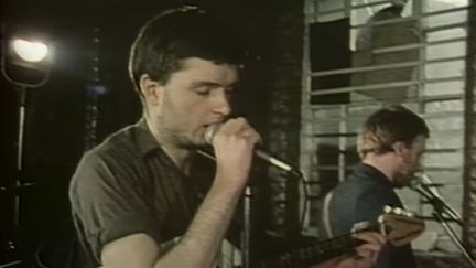 Ian Curtis du groupe Joy Division dans le clip de la chanson "Love Will Tear Us Apart" (Capture écran). (YOUTUBE)