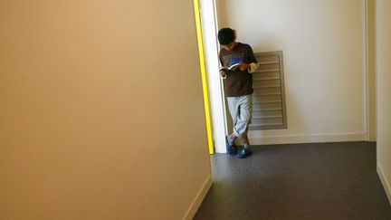 Un élève lit un livre dans le couloir du collège Auguste Renoir d'Asnières-sur-Seine, au nord de Paris. (FRED DUFOUR / AFP)