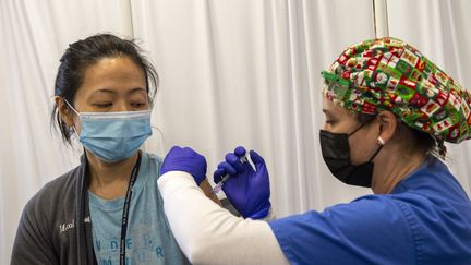 Une médecin de l'armée de l'air américaine reçoit une injection d'un vaccin contre le Covid-19, le 23 décembre 2020 à Boston (Massachusetts, Etats-Unis). (JOSEPH PREZIOSO / AFP)