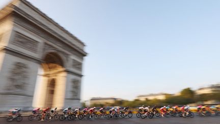 Le peloton devant l'Arc de Triomphe, l'une des images marquantes de la dernière journée du Tour de France. (KENZO TRIBOUILLARD / AFP)