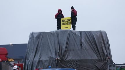 Des militants de l'organisation écologiste Greenpeace qui bloquent le camion&nbsp;transportant le couvercle de la cuve de l'EPR de Flamanville, le 12 février 2016. (CHARLY TRIBALLEAU / AFP)