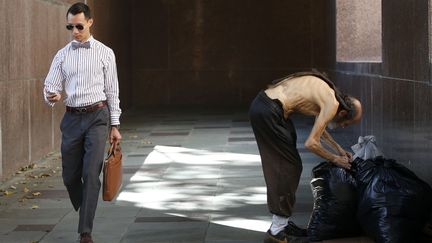 Un SDF (D) cherche dans ses sacs pr&egrave;s d'un tribunal &agrave; Los Angeles (Californie, Etats-Unis), le 8 juillet 2014. (LUCY NICHOLSON / REUTERS)