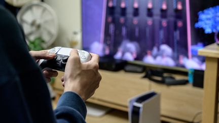 Un joueur teste la nouvelle PlayStation 5 dans son salon. Photo d'illustration.
 (YELIM LEE / AFP)