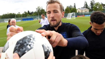 L'attaquant anglais Harry Kane signe un ballon tendu par un supporter, à Zelenogorsk (Russie), le 13 juin 2018. (PAUL ELLIS / AFP)