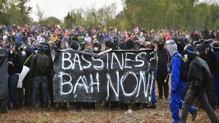 Des manifestants brandissent une banderole lors du rassemblement contre un projet de réserve d'eau artificielle, à Sainte-Soline (Deux-Sèvres), samedi 25 mars 2023. (PASCAL LACHENAUD / AFP)