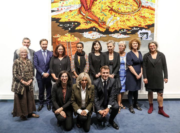 Les lissières qui ont travaillé sur "Conversation with Smaug" posent devant leur création en compagnie du couple Macron, de la minstre de la culture&nbsp;Rima Abdul Malak et de Stéphane Berne. (STEPHANE LEMOUTON - POOL/SIPA)