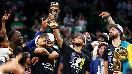 Stephen Curry brandit le trophée de meilleur joueur de la finale, après la victoire de Golden State face à Boston, jeudi 16 juin 2022. (ELSA / GETTY IMAGES NORTH AMERICA)