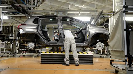 Un ouvrier travaille sur une chaîne de montage d'une Peugeot 2008 dans l'usine PSA de Mulhouse (Haut-Rhin), le 10 octobre 2017. (SEBASTIEN BOZON / AFP)