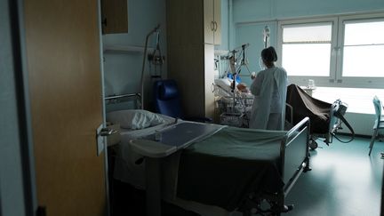 Une soignante s'occupe d'un patient atteint du Covid-19 à l'hôpital Emile Muller à Mulhouse, le 16 février 2021. Photo d'illustration. (SEBASTIEN BOZON / AFP)