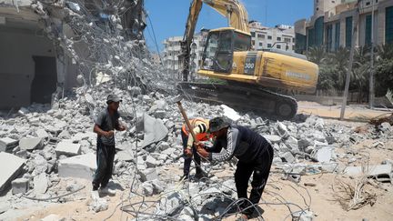 Des ouvriers&nbsp;travaillent dans les décombres plusieurs semaines après des bombardements, le 27 juillet 2021 à Gaza (Palestine). (MAJDI FATHI / NURPHOTO / AFP)