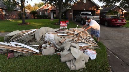 Un habitant sort les débris de sa maison après le passage de la tempête Harvey à Houston (Texas), le 31 août 2017. (MARK RALSTON / AFP)