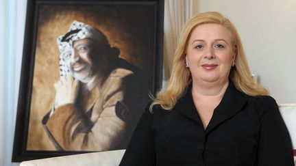 Souha Arafat pose devant le portrait de son d&eacute;funt mari, Yasser Arafat, en novembre 2011 &agrave; Malte. (MATTHEW MIRABELLI / AFP)