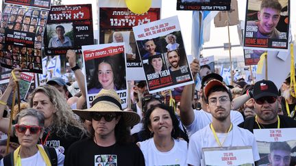 Des manifestants brandissent les portraits d'otages retenus par le Hamas, lors d'un rassemblement organisé le 18 novembre 2023, à Jérusalem. (LAETITIA NOTARIANNI / AFP)