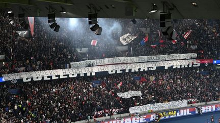 Des banderoles en soutien aux victimes du Moyen-Orient ont fleuri dans le virage Auteuil, à l'occasion du match de Ligue des champions entre le PSG et l'AC Milan, le 25 octobre 2023. (BERTRAND GUAY / AFP)