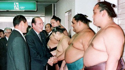 Le président Chirac en novembre 1996, à Fukuoka, au Japon félicitant les lutteurs avant un grand match.&nbsp; (JIJI PRESS / AFP)