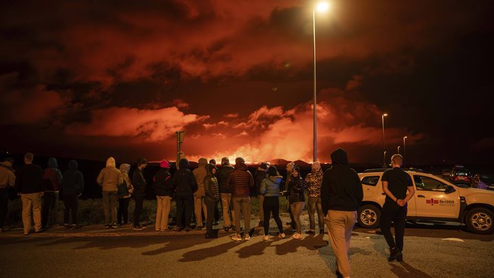 Des curieux observent une nouvelle éruption volcanique sur la péninsule de Reykjanes, le 22 août 2024. (MARCO DI MARCO / AP / SIPA)