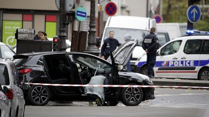 Des policiers mènent les premières constatations sur l'une des voitures des commandos des&nbsp;attentats du 13-Novembre, retrouvée dans le 18e arrondissement de Paris, le 17 novembre 2015. (KENZO TRIBOUILLARD / AFP)