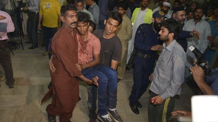 Un blessé est évacué après l'explosion à Lahore (Pakistan), le 27 mars 2016. (ARIF ALI / AFP)