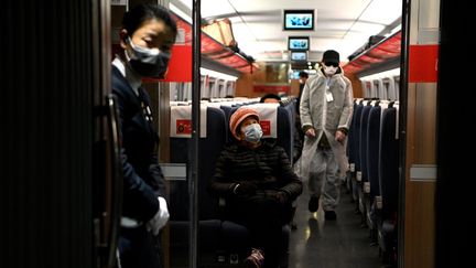 Des personnes masquées à l'intérieur d'un train,&nbsp;dans la gare de Hongqiao à Shanghai (Chine), le 2 mars 2020. (NOEL CELIS / AFP)