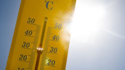 Un thermomètre devant un soleil cuisant. (DAMIEN MEYER / AFP)