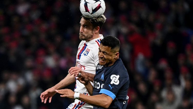 Nicolas Tagliafico and Alexis Sanchez in the duel during Lyon-Marseille, in Ligue 1, April 23, 2023. (OLIVIER CHASSIGNOLE / AFP)