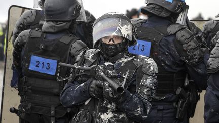 Des membres des forces de l'ordre font face aux manifestants aux abords des Champs-Elysées, samedi 1er décembre 2018. (GEOFFROY VAN DER HASSELT / AFP)