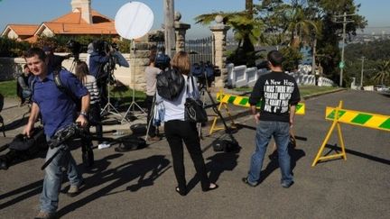 Des journalistes s'éloignent du domicile de la jeune fille qui était attachée à un "engin suspect". (TORSTEN BLACKWOOD / AFP)