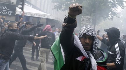 Un manifestant pro-palestinien l&egrave;ve le poing pendant un d&eacute;fil&eacute; de soutien &agrave; la population gazaouie, le 13 juillet &agrave; Paris. (KENZO TRIBOUILLARD / AFP)