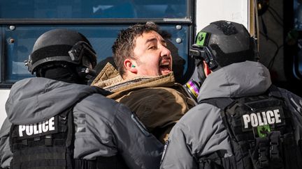 Des policiers arrêtent un manifestant à Ottawa, au Canada, le 18 février 2022. (ANDREJ IVANOV / AFP)