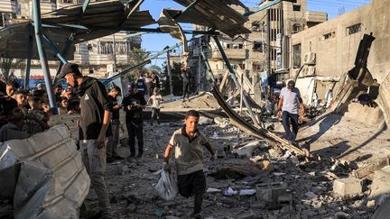 Des personnes fouillent les décombres d'un bâtiment effondré à la suite d'un bombardement israélien à l'école al-Jaouni à Nousseirat, dans le centre de la bande de Gaza, le 6 juillet 2024. (EYAD BABA / AFP)