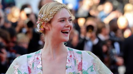 L'actrice américaine et membre du jury Elle Fanning célèbre le beau temps cannois avec un joli sourire et une robe printannière. (VALERY HACHE / AFP)