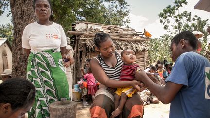Un membre d'Action contre la faim mesure le bras d'un enfant pour détecter une possible malnutrition, àItofaka (Madagascar), le 14 décembre 2018. (RIJASOLO / AFP)